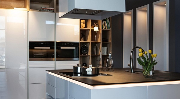 Moderne Küche mit Kochinsel, Induktionsherd, gelben Tulpen und stilvoller Beleuchtung.