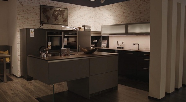 Moderne Einbauküche mit Kochinsel, dunklen Fronten und stilvoller Beleuchtung.