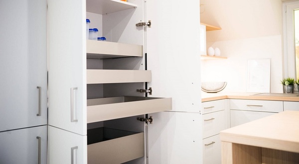 Moderner Küchenschrank mit offenen Auszügen und praktischem Stauraumsystem in heller Küche.